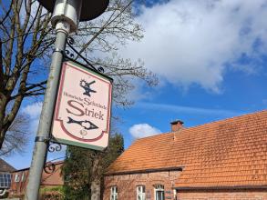 Schild vor der historischen Schmiede in Großefehn