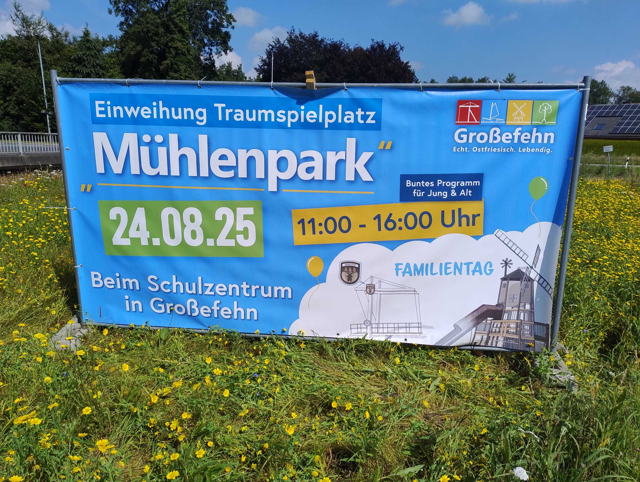 Das Bild zeigt das Werbebanner mit blauem Untergrund und Ballons, Mühle etc.